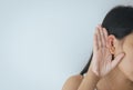 Woman hold up hand near ear and listening intend carefully,Because of the noise low volume