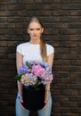 Woman hold vase with hydrangea flowers on brick wall Royalty Free Stock Photo