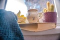 Woman holdig a Cup of autumn tea, coffee, and yellow dry leaves near a window, Royalty Free Stock Photo