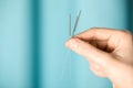 Woman holding acupuncture needles on color background, closeup. Space for text Royalty Free Stock Photo