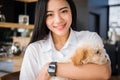 Woman holding adorable dog at cafe restaurant. female teenager w Royalty Free Stock Photo