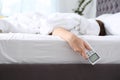 Woman holding air conditioner remote control in bed on hand Royalty Free Stock Photo