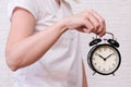 Woman holding an alarm clock showing 10 oclock, people should value and appreciate time, deadline concept