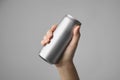 Woman holding aluminum can with beverage on grey background, closeup. Royalty Free Stock Photo