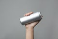 Woman holding aluminum can with beverage on grey background, closeup. Royalty Free Stock Photo