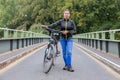 Woman holding ATB mountainbike on bridge