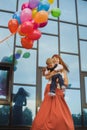 Woman holding  baby in her arms, joy and fun, balloons of different colors Royalty Free Stock Photo