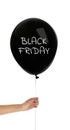 Woman holding balloon with text BLACK FRIDAY on background, closeup Royalty Free Stock Photo