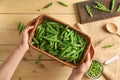 Woman holding basket with fresh green peas on wooden background Royalty Free Stock Photo