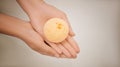 Woman holding bath bomb on light background, closeup. Space for text Royalty Free Stock Photo