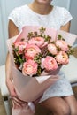 Woman holding a beautiful bouquet of large roses in a kraft paper Royalty Free Stock Photo