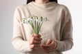 Woman holding beautiful bouquet of snowdrops on light background, closeup Royalty Free Stock Photo