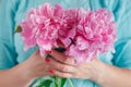 Woman holding beautiful pink peonies. Girl with bouquet of flowers in her hands. Closeup of hands holding bunch of peonies. Royalty Free Stock Photo