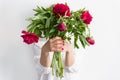 Woman holding beautiful red peonies. Girl with bouquet of flowers in her hands. Closeup of hands holding peonies Royalty Free Stock Photo