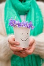 Woman holding beautiful snowdrops in a paper cup. first spring flowers in a forest. Wild flowers. spring concept Royalty Free Stock Photo