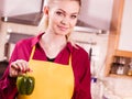 Woman holding bell pepper paprika thinking