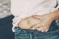 Woman holding belly fat abdominal with fingers hand. Concept of body acceptance and positivity. Diet and nutrition for healthy Royalty Free Stock Photo