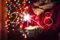 Woman holding sparkles on his hand on bokeh lights background. New YearÃ¢â¬â¢s Eve concept. 2018 written with sparkle fireworks. Royalty Free Stock Photo