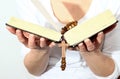Woman holding a bible and rosary beads cross in her hands Royalty Free Stock Photo