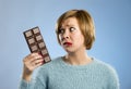 Woman holding big chocolate bar with mouth stains and guilty face expression in sugar addiction Royalty Free Stock Photo