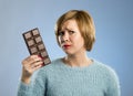 Woman holding big chocolate bar with mouth stains and guilty face expression in sugar addiction Royalty Free Stock Photo