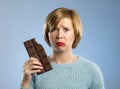 Woman holding big chocolate bar with mouth stains and guilty face expression in sugar addiction Royalty Free Stock Photo