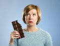 Woman holding big chocolate bar with mouth stains and guilty face expression in sugar addiction Royalty Free Stock Photo