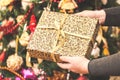 Woman holding a big gift box against amazing christmas tree background. Toned and selective focus Royalty Free Stock Photo