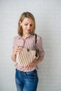 Woman holding big knitted purse isolate on brick background. Closeup