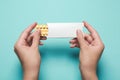 Woman holding birth control pills on light blue background, top view Royalty Free Stock Photo