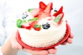 Woman holding birthday strawberry cake with strawberries
