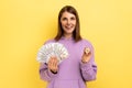 Woman holding bitcoin and big fan of dollar bills, exchange crypto currency.