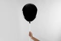 Woman holding black balloon for Halloween party on light grey background Royalty Free Stock Photo