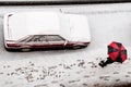 Woman holding a black and red umbrella under snow Royalty Free Stock Photo