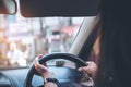 Woman holding on black steering wheel while driving a car Royalty Free Stock Photo