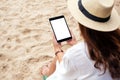 A woman holding a black tablet pc with blank desktop screen while sitting on a beach chair Royalty Free Stock Photo