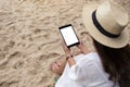 A woman holding a black tablet pc with blank desktop screen while sitting on a beach chair Royalty Free Stock Photo