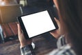 A woman holding black tablet pc with blank white desktop screen in cafe