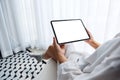 A woman holding black tablet pc with blank white desktop screen while sitting in bedroom with feeling relaxed in Royalty Free Stock Photo