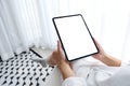 A woman holding black tablet pc with blank white desktop screen while sitting in bedroom with feeling relaxed in Royalty Free Stock Photo