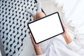 A woman holding black tablet pc with blank white desktop screen while sitting in bedroom with feeling Royalty Free Stock Photo
