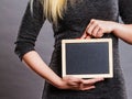 Woman holding blank black board on stomach
