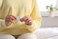 Woman holding blister of emergency contraception pills in bedroom, closeup Royalty Free Stock Photo