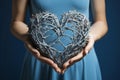 A woman holding a blue heart shaped object in her hands