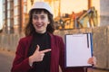 Woman holding blueprints, clipboard. Smiling architect in helmet at building Royalty Free Stock Photo