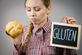 Woman holding board with gluten sign and bun bread