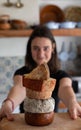 Woman holding a board with variety of cheeses. Cheese tower