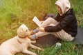 The woman is holding a book in her hands. Reading in the park, in the forest. Rest, training, relaxation concept