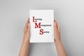 Woman holding book with text Learning Management System and red initial letters forming initialism LMS on white background,