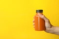 Woman holding bottle of carrot juice, closeup with space for text Royalty Free Stock Photo